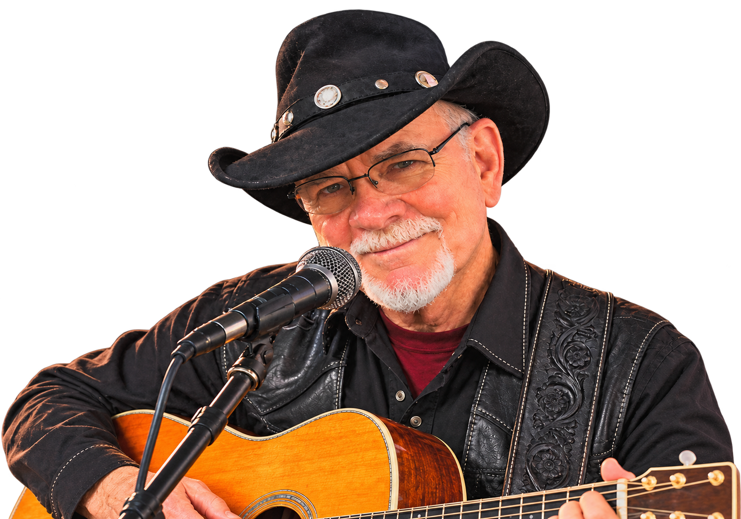 Josh Logan singing into a microphone while playing acoustic guitar